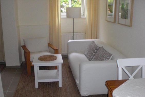 Wohnung im Souterrain einer Stadtvilla, Wohnraum mit Tisch u.Sesseln